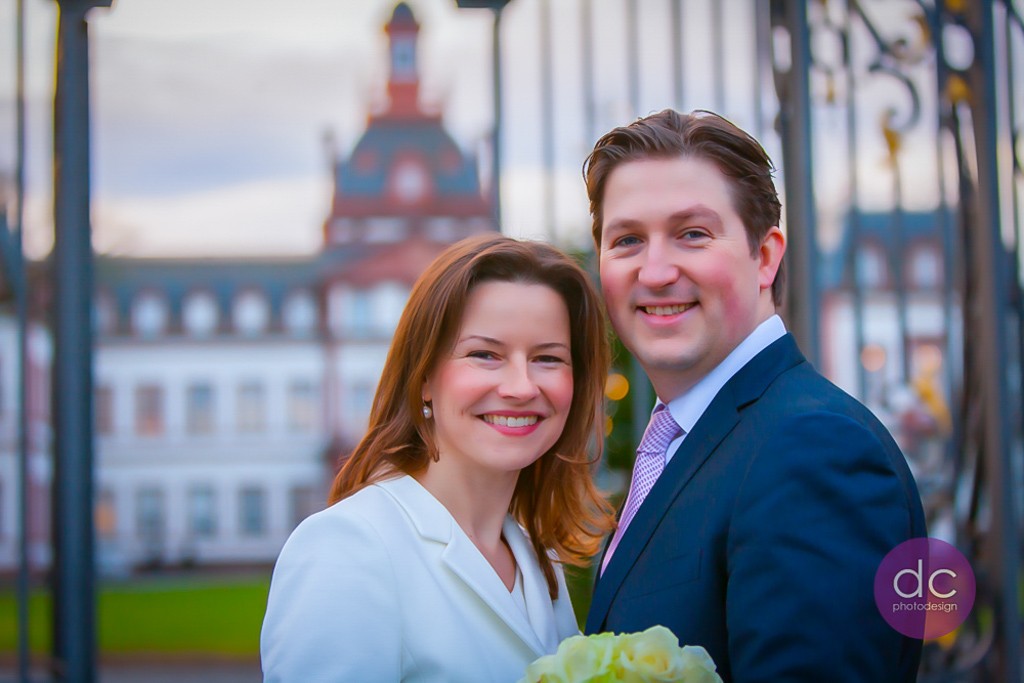 Glückliches und strahlendes Brautpaar am Haupttor Schloss Philippsruhe - Hochzeitsfotograf Hanau